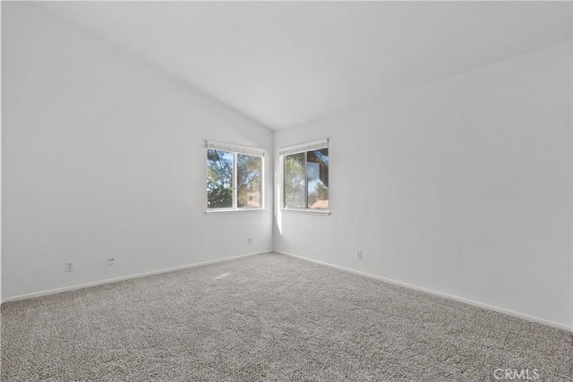 carpeted spare room featuring lofted ceiling