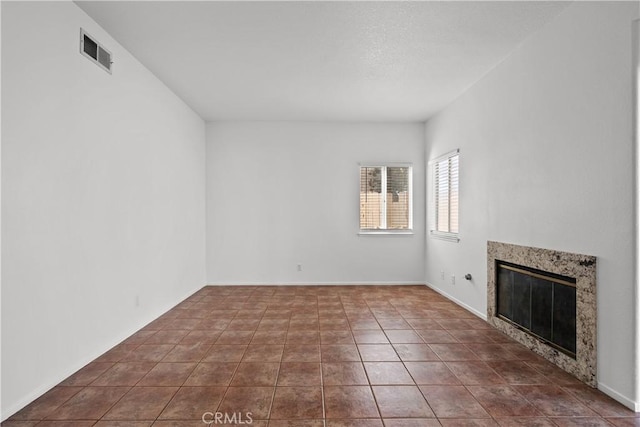 unfurnished living room with tile patterned floors and a premium fireplace