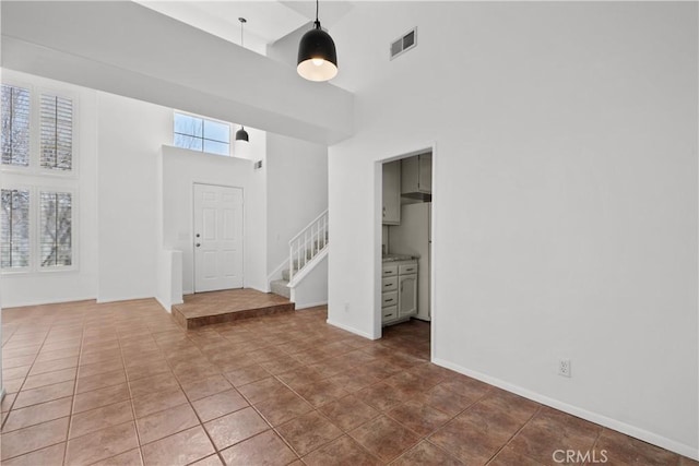 tiled foyer with a wealth of natural light and a towering ceiling