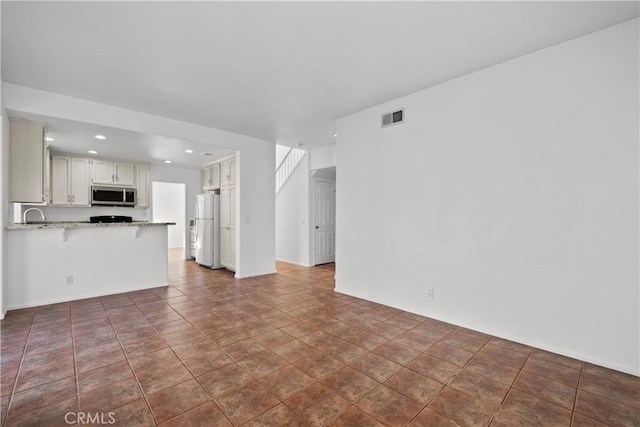 unfurnished living room with dark tile patterned flooring