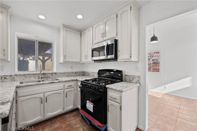 kitchen with white cabinets, sink, light tile patterned floors, and black range with gas cooktop