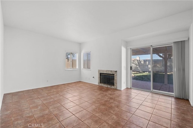 unfurnished living room featuring a high end fireplace and light tile patterned flooring