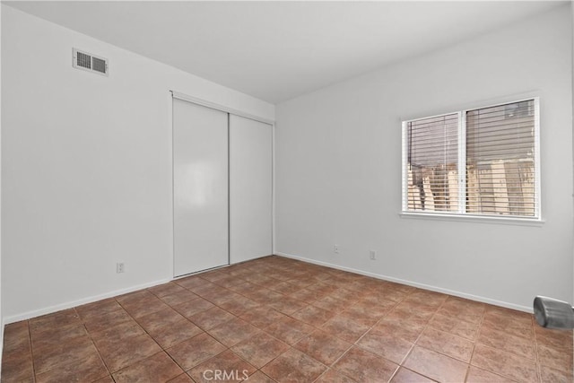 unfurnished bedroom with a closet and tile patterned flooring