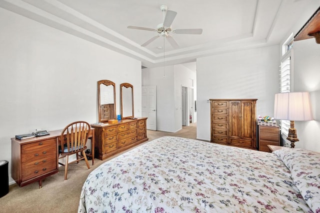 bedroom featuring ceiling fan, light colored carpet, and a raised ceiling