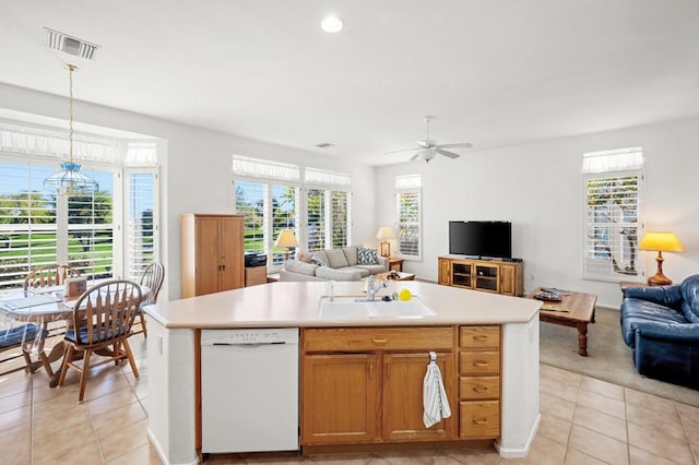 kitchen featuring white dishwasher, a center island with sink, pendant lighting, and sink