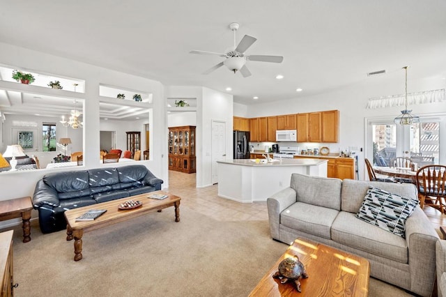 living room with ceiling fan with notable chandelier, light colored carpet, and french doors