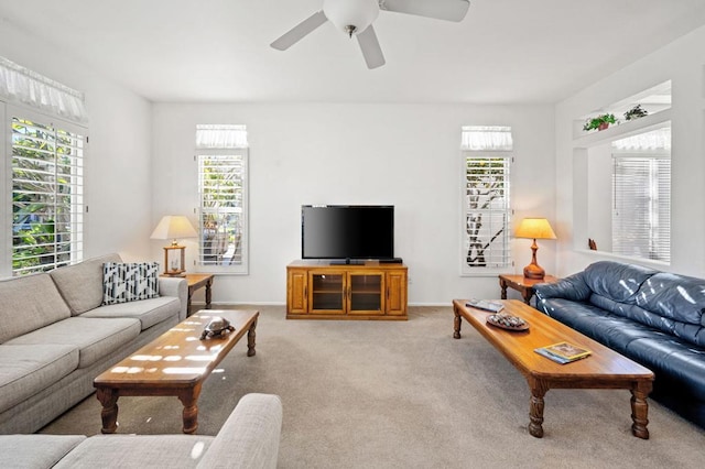 living room with ceiling fan, light colored carpet, and plenty of natural light