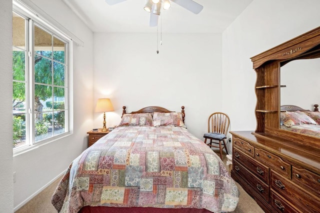 bedroom featuring ceiling fan, multiple windows, and carpet flooring