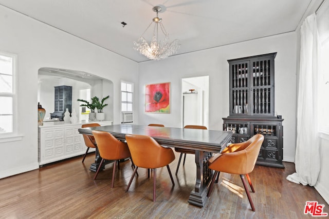 dining space featuring wood-type flooring and a notable chandelier