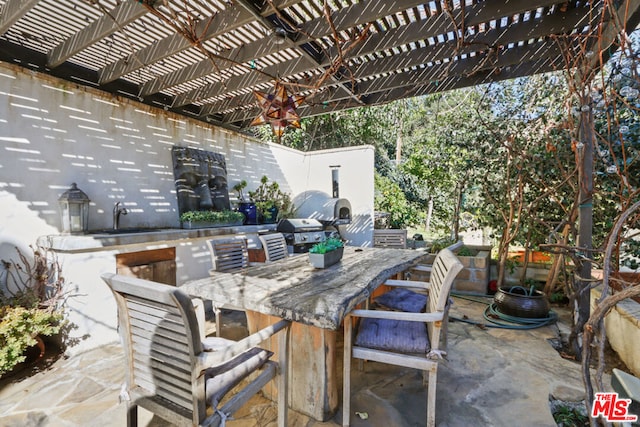 view of patio featuring a pergola, a grill, and an outdoor wet bar