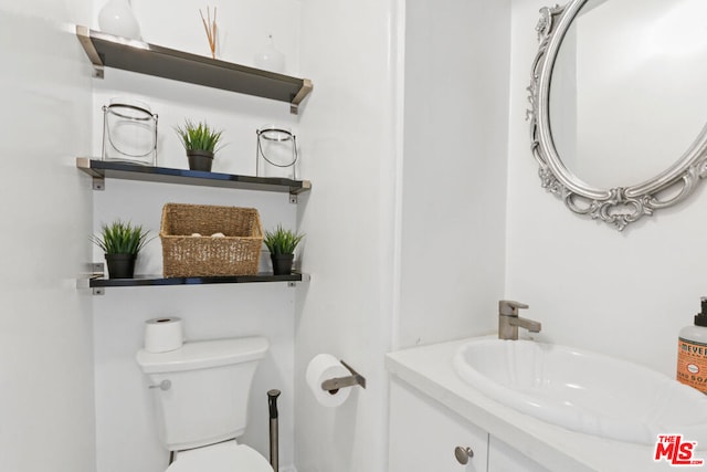 bathroom featuring toilet and vanity