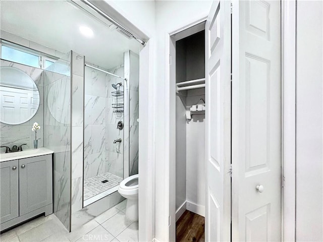 bathroom with toilet, a shower with shower door, and vanity