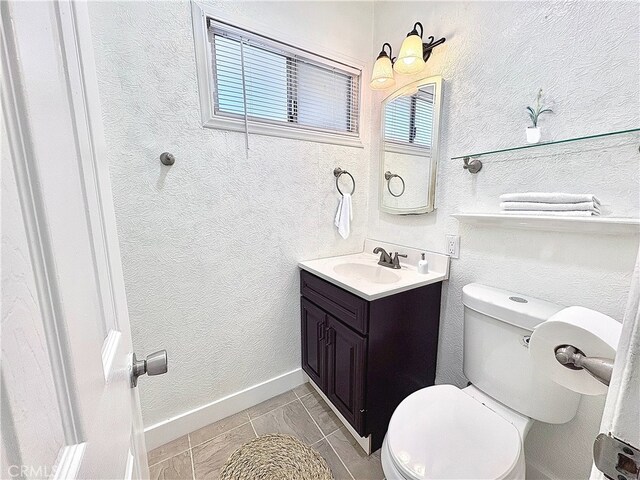 bathroom featuring toilet, tile patterned flooring, and vanity