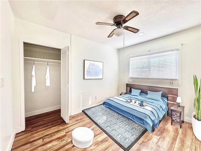 bedroom featuring ceiling fan, a closet, a textured ceiling, and hardwood / wood-style flooring