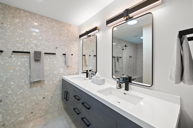 bathroom with a tile shower and vanity