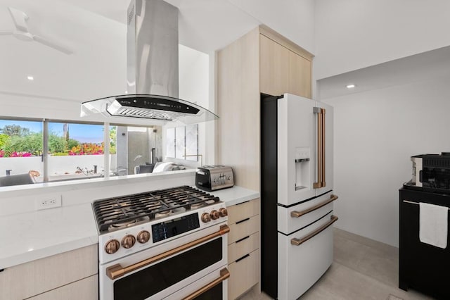 kitchen featuring island range hood, stainless steel range, ceiling fan, light brown cabinetry, and white refrigerator with ice dispenser