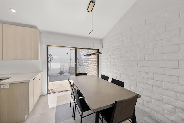 tiled dining space featuring vaulted ceiling