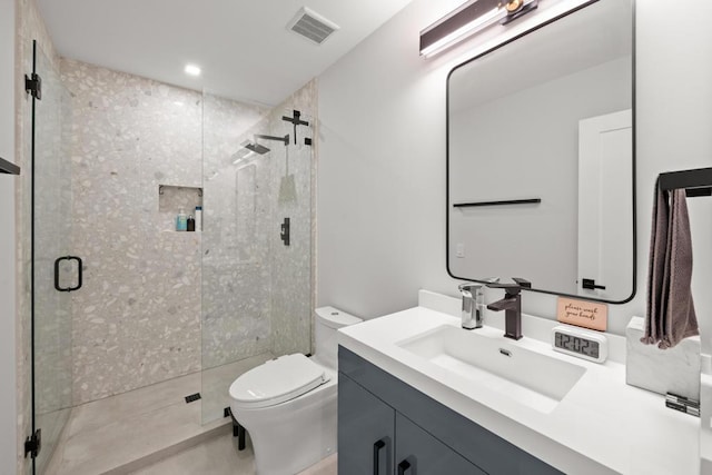 bathroom featuring toilet, an enclosed shower, and vanity