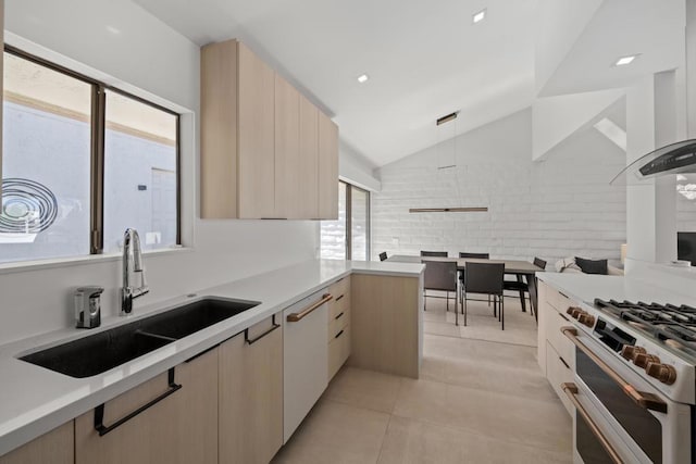 kitchen featuring light brown cabinets, white appliances, light tile patterned flooring, vaulted ceiling, and sink