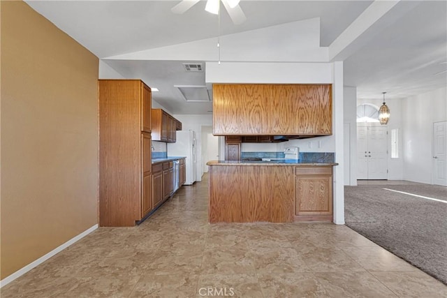 kitchen featuring ceiling fan with notable chandelier, lofted ceiling, decorative light fixtures, white refrigerator, and kitchen peninsula