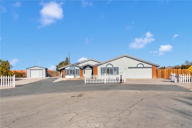 ranch-style house with a garage and an outbuilding