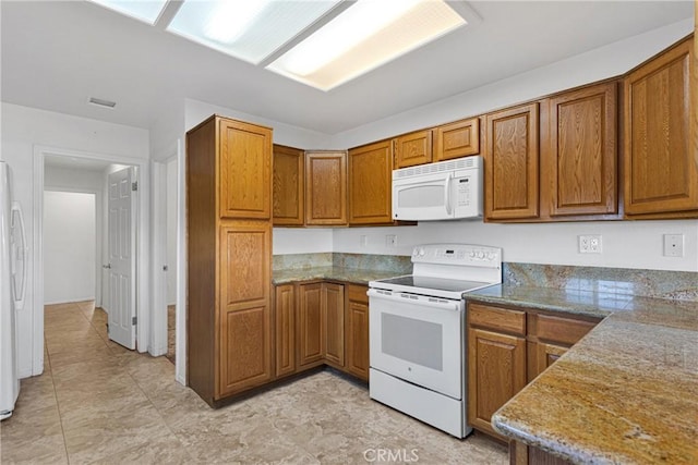 kitchen featuring stone countertops and white appliances