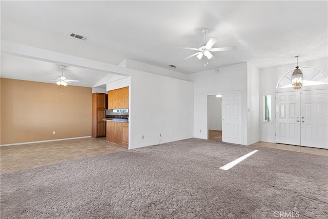 unfurnished living room with light carpet and ceiling fan