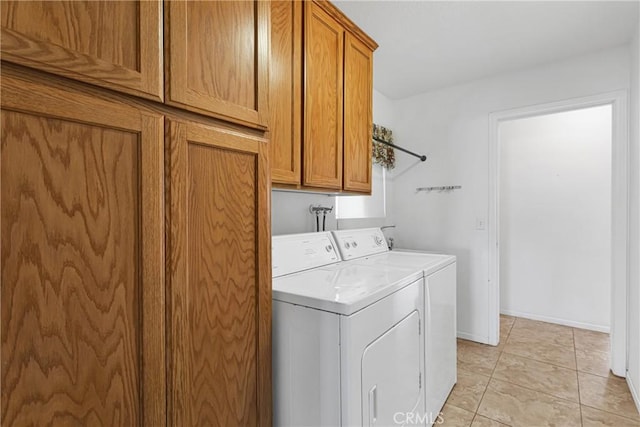 laundry area featuring light tile patterned floors, cabinets, and washer and clothes dryer