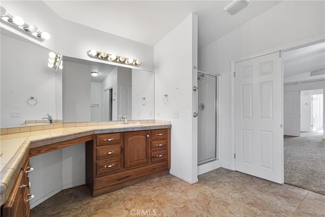 bathroom featuring lofted ceiling, a shower with shower door, and vanity