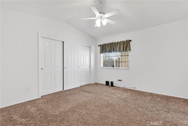 unfurnished bedroom featuring ceiling fan, carpet, a closet, and vaulted ceiling