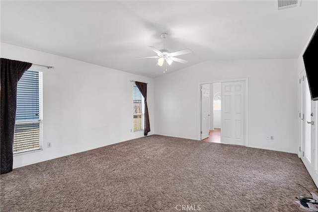 carpeted spare room with ceiling fan, lofted ceiling, and plenty of natural light