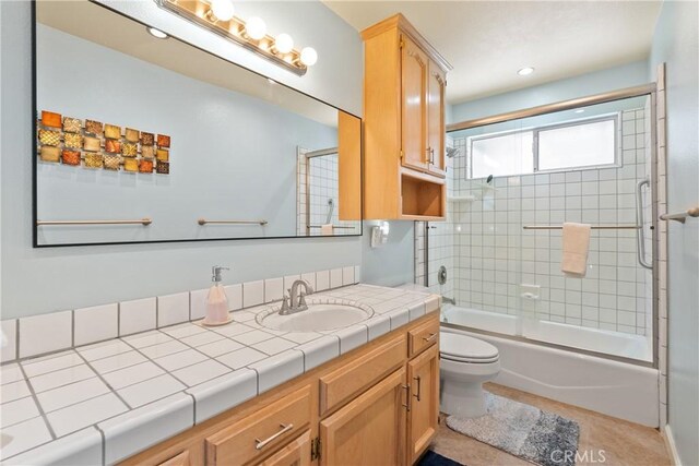 full bathroom with toilet, combined bath / shower with glass door, tile patterned flooring, and vanity