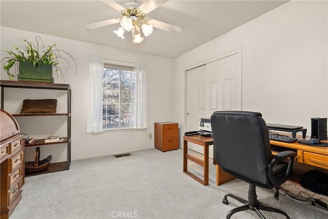 carpeted home office with ceiling fan