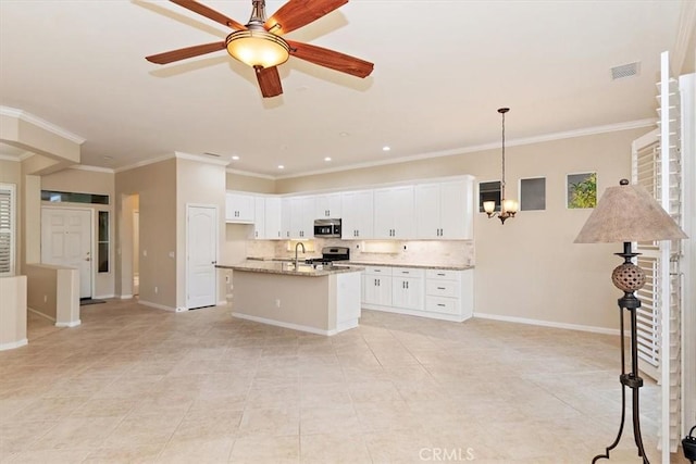 kitchen with stainless steel appliances, baseboards, visible vents, and a center island with sink