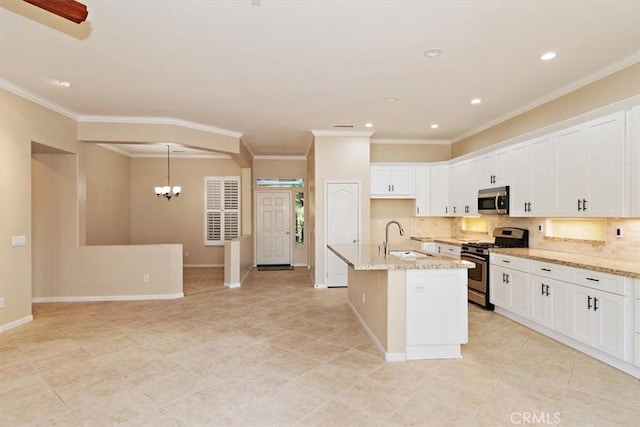 kitchen with a sink, white cabinets, light stone countertops, and stainless steel appliances