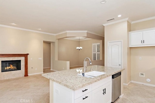 kitchen with visible vents, a sink, light stone counters, stainless steel dishwasher, and baseboards