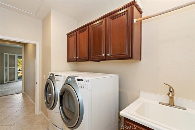 clothes washing area with independent washer and dryer, a sink, cabinet space, light tile patterned floors, and baseboards