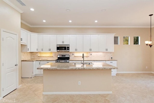 kitchen with an island with sink, a sink, stainless steel appliances, crown molding, and light stone countertops