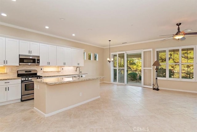 kitchen with a kitchen island with sink, a sink, backsplash, stainless steel appliances, and crown molding