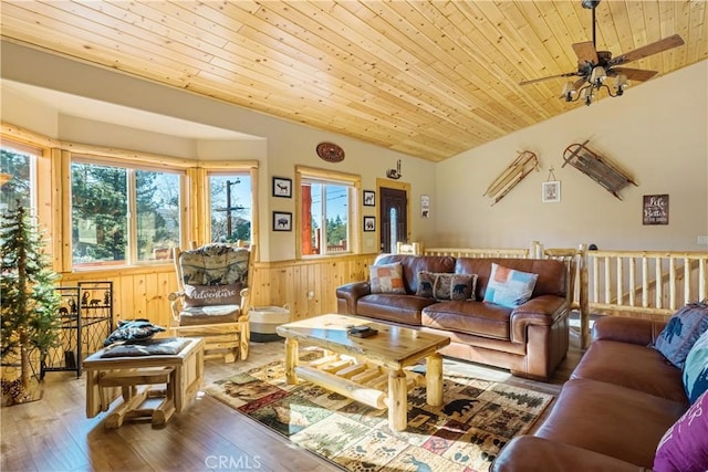 living room with lofted ceiling, wood ceiling, wood-type flooring, wood walls, and ceiling fan