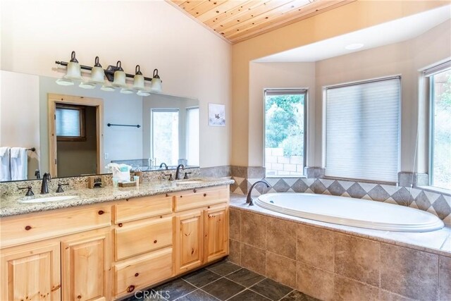 bathroom featuring tiled tub, vanity, wood ceiling, and vaulted ceiling