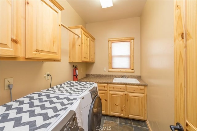 clothes washing area featuring cabinets, sink, and independent washer and dryer