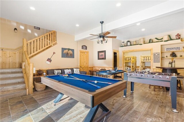 recreation room featuring ceiling fan and beamed ceiling