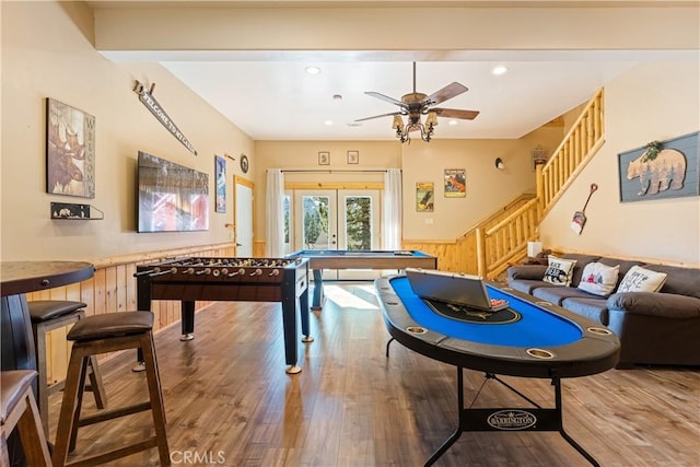 playroom featuring ceiling fan, french doors, wood walls, and hardwood / wood-style flooring