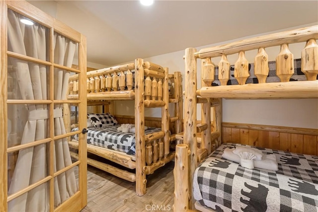 bedroom with hardwood / wood-style flooring and wooden walls