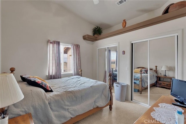 carpeted bedroom with multiple closets and lofted ceiling