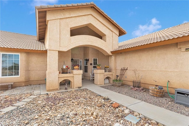 rear view of property with exterior fireplace