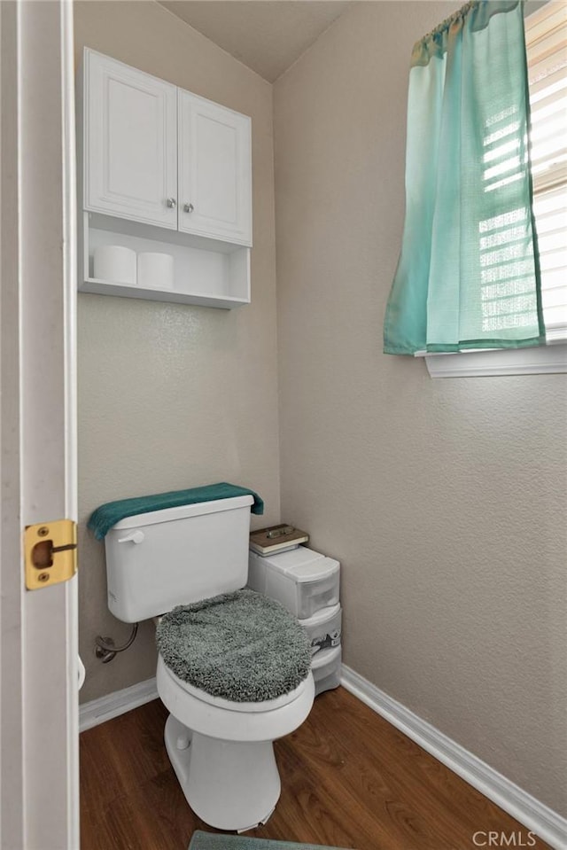 bathroom with toilet and wood-type flooring