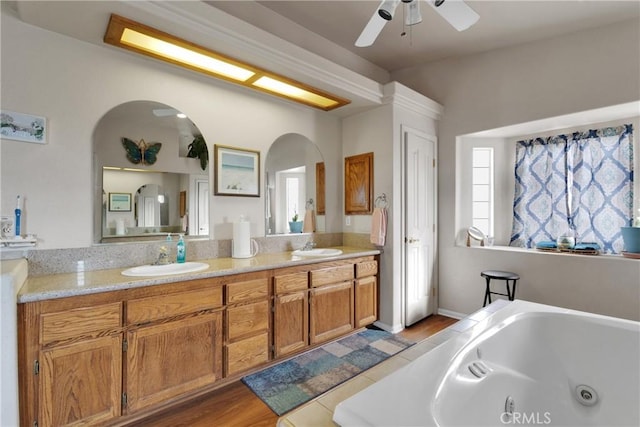 bathroom with ceiling fan, vanity, a tub to relax in, and hardwood / wood-style floors