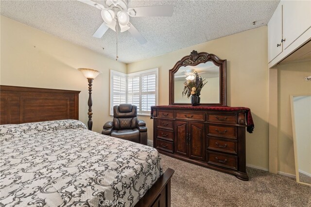 carpeted bedroom featuring ceiling fan and a textured ceiling